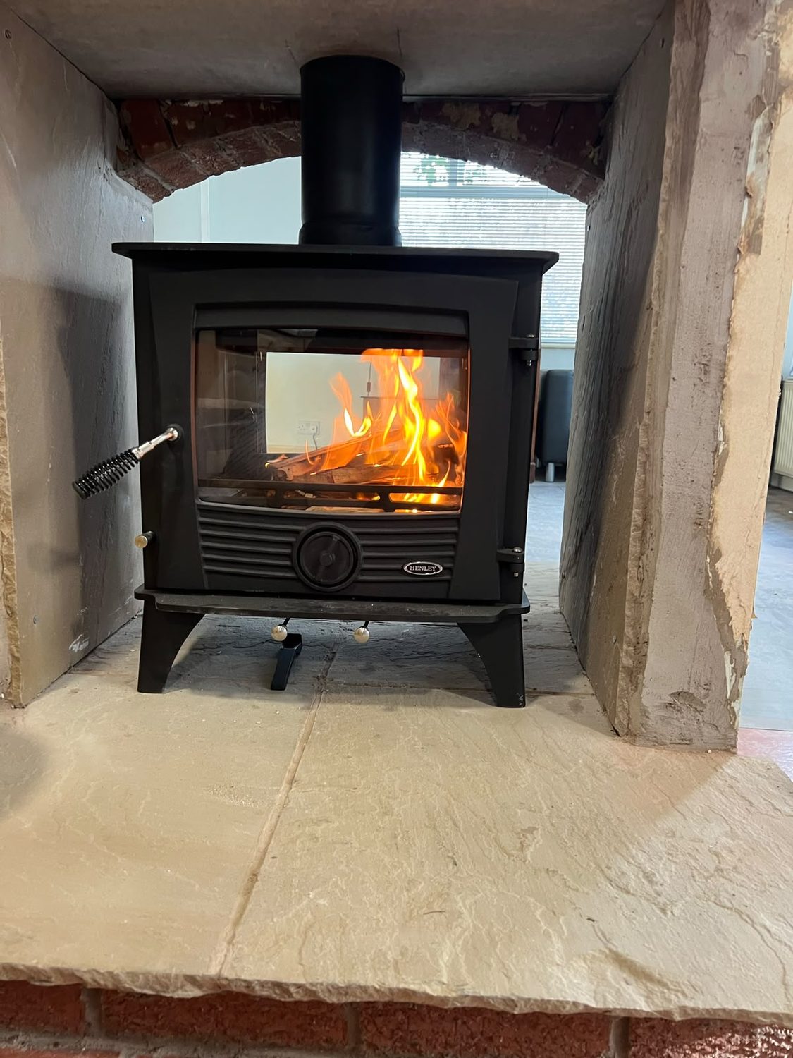 Freestanding stove burning in a sandstone arched chamber